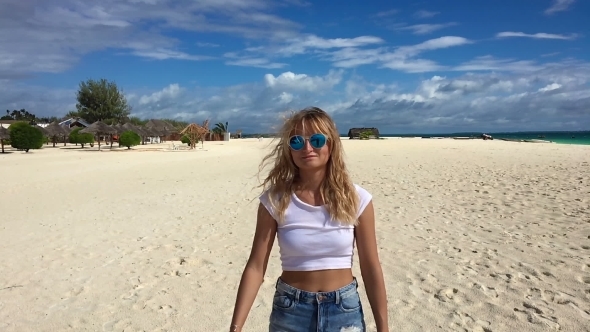 An Attractive Girl Walks Along the Beach and Flirts with the Camera.