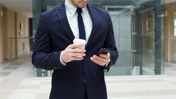 Businessman in Black Suit Drinking Takeaway Coffee and Use Smartphone