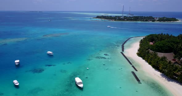 Tropical flying tourism shot of a white sandy paradise beach and blue sea background in colourful 4K