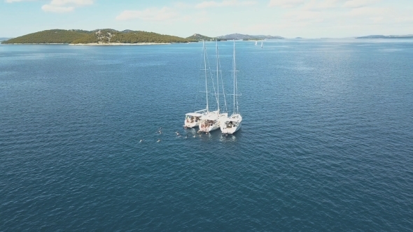 Three Sailing Yachts Are Connected, Near Beautiful Islands. Beautiful Clouds in the