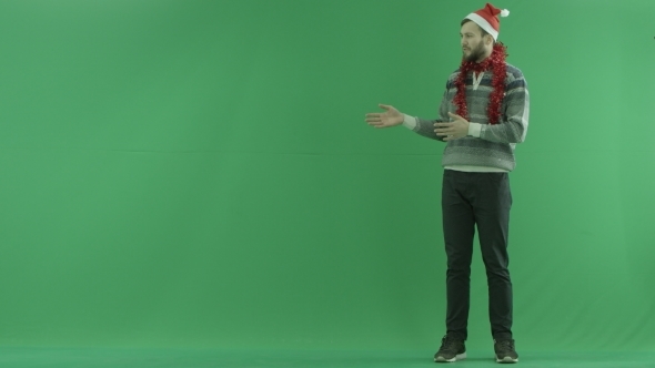 Young Bearded Man Shows Something Near Him and Talks, Green Chroma Key Background