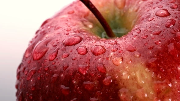 Beautiful Red Apple with Water Drops Rotates on White Background,