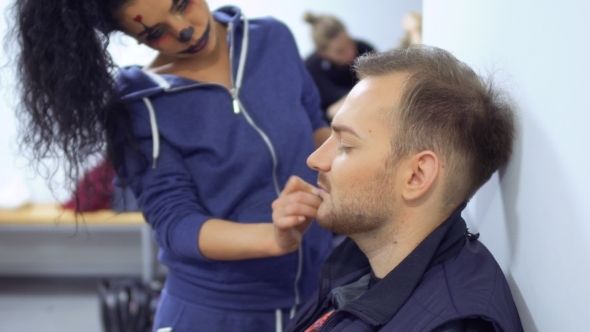 Woman with Horrible Greasepaint on Face Help Colleague and Makes Make-up for Him