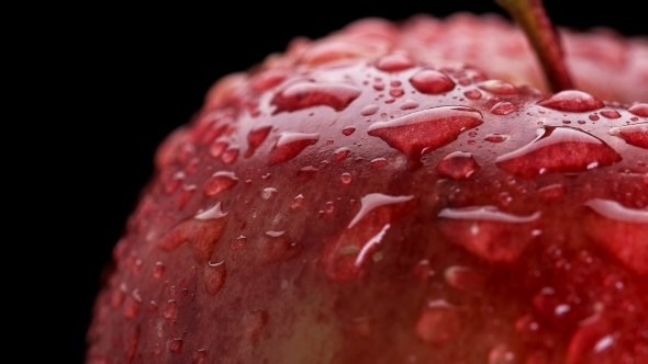 Beautiful Red Apple with Water Drops Rotates on Black Background,