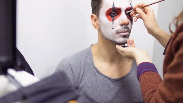 Make-up Artist Makes Greasepaint on Man's Face Before His Performance on Scene