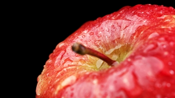 Beautiful Red Apple with Water Drops Rotates on Black Background,