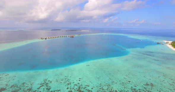 Aerial drone view of a man and woman couple snorkeling over the coral reef of a tropical island