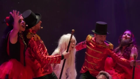 People in Bright Costumes Sings Song on Colorful Stage in Theatre