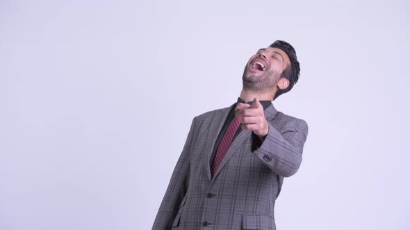 Happy Bearded Persian Businessman Laughing and Pointing at Camera