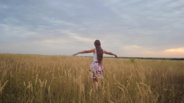 Teenager Spreads Her Arms Like Wings and Walks Across Field