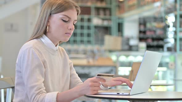 Online Payment on Laptop By Young Woman in Cafe