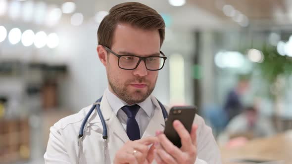 Portrait of Focused Male Doctor Using Smartphone