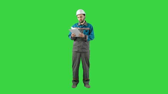 Engineer Man Verify and Read Files Documents on a Green Screen, Chroma Key.