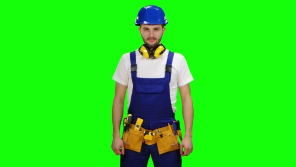 Builder Stands and Looks into the Distance and Smiles on Green Screen