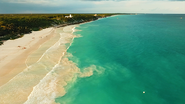 Aerial Footage of Tulum Beach During Sunset. Drone View of Shoreline, People, Ocean Waves