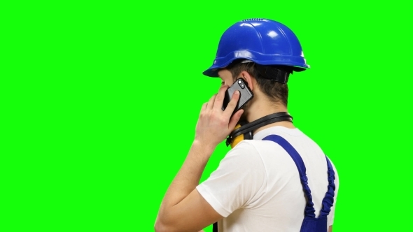 Engineer in a Blue Helmet Speaks on the Phone and Shows a Thumbs up on Green Screen