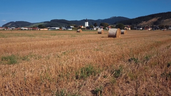 Flying Above Field with Round Haystacks