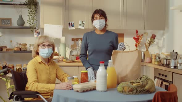 Volunteer And Senior Woman In Kitchen