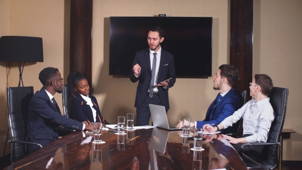 Businessman Presenting To Colleagues at a Meeting.