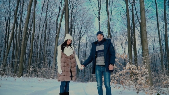 Couple Walking through the Winter Forest