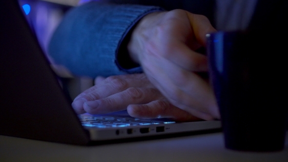 Hands of a Man Working By Computer Late Night