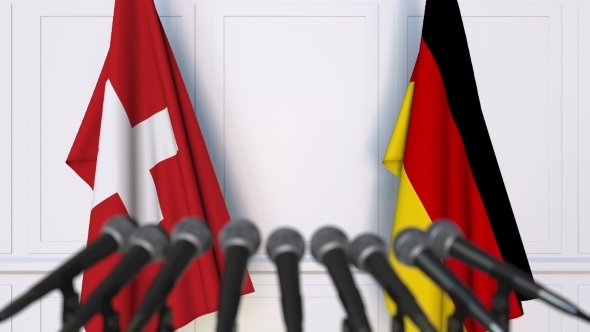 Flags of Switzerland and Germany at International Press Conference alt