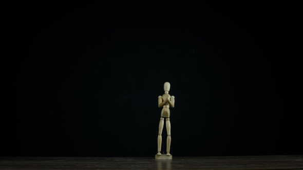 Stopmotion Wooden Figure Dummy Applauds in Studio on Black Background
