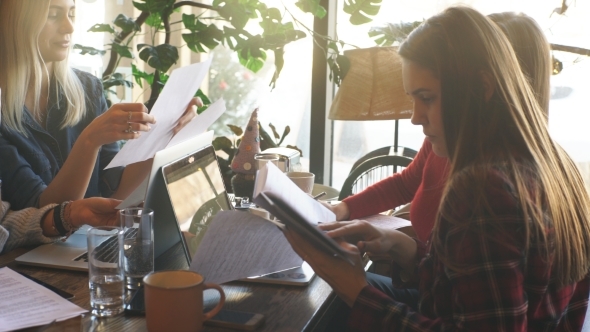 Company Businessman Discussing Documents Sitting in a Cafe