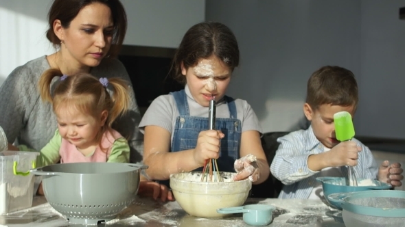 A Young Mother with Three Children Prepares Dough for Dumplings and Ravioli. Slavic Cuisine