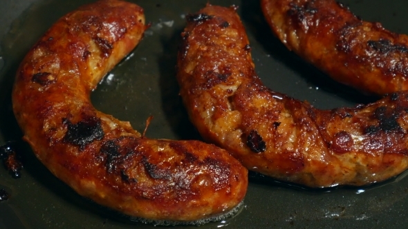 Overhead  Frying Link Sausage Fast Food in Cast Iron Skillet