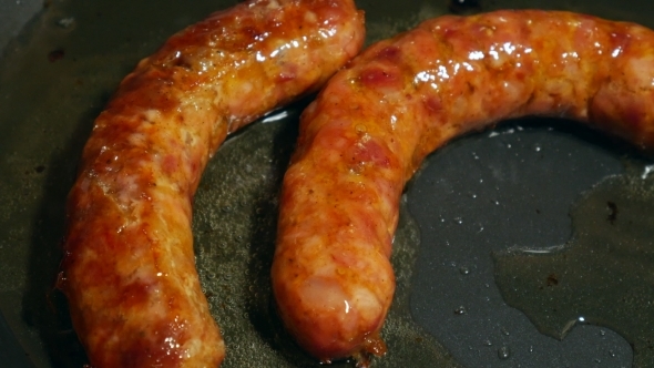 Overhead  Frying Link Sausage Fast Food in Cast Iron Skillet