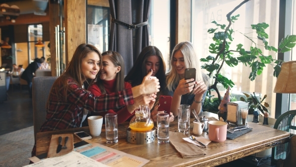 Four Beautiful Young Women Doing Selfieand Having Fun in a Cafe