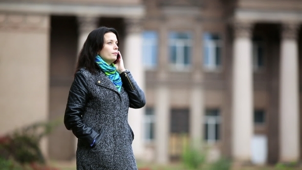 Woman Speak Phone and Smile Happily in the Autumn Park