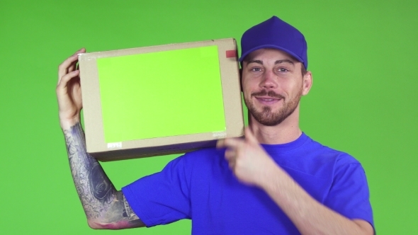 Happy Deliveryman Smiling Putting Cardboard Box with Copyspace on His Shoulder