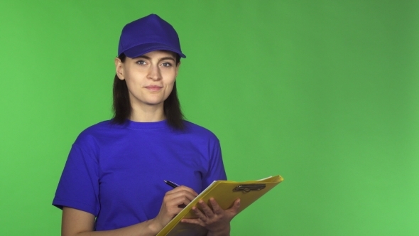 Young Delivery Woman Checking Papers on a Clipboard Smiling To the Camera