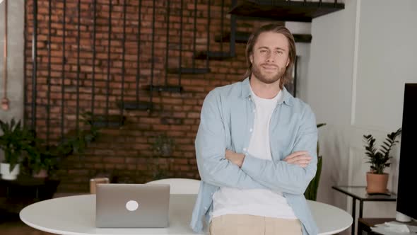 Portrait of a Handsome Man at His Workplace with a Laptop in a Stylish Loft Coworking