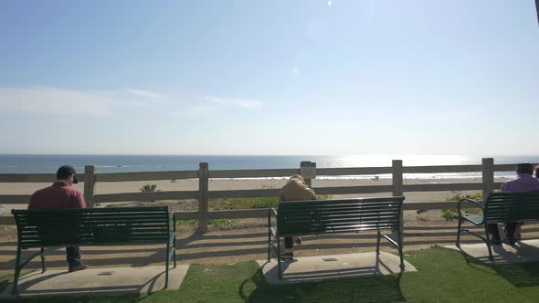 Tourists relaxing on benches near the beach