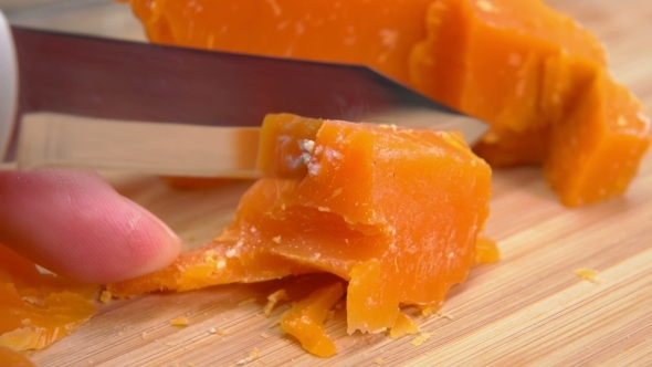Mimolette Cheese Cut with Cheese Knife on a Bamboo Board