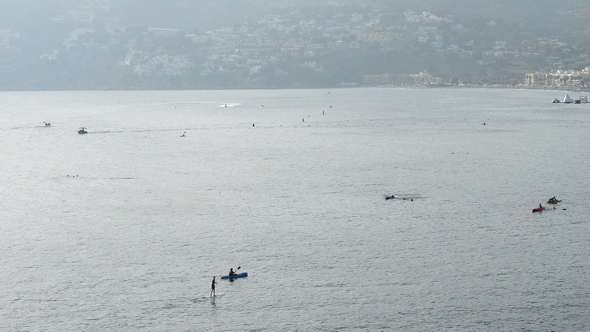 People with Kayaks and Canoes at Sunset