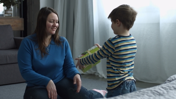 Cute Son Giving Gift Box To Mom on Mother's Day