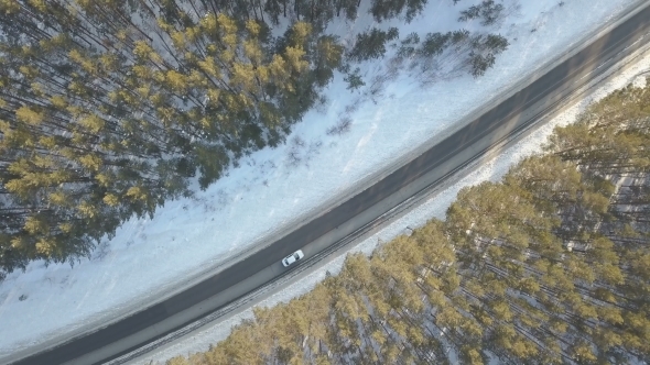 Snowy Road with a Moving Car in Winter