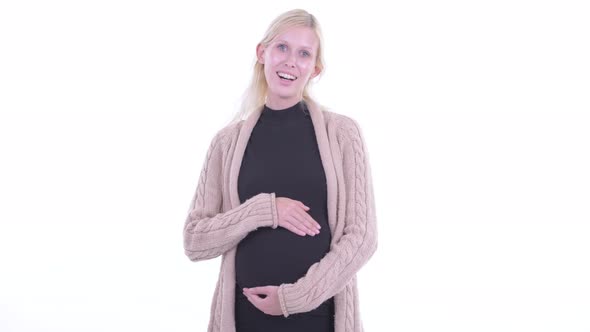 Happy Young Blonde Pregnant Woman Smiling and Holding Belly