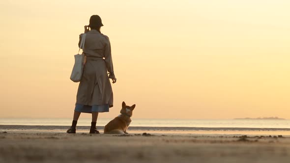 Dog and Woman Stand By Water While Travel to Sea at Sunset Spbi