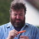 Bearded man is skeptical about fresh carrot and healthy diet. Concept idea - VideoHive Item for Sale