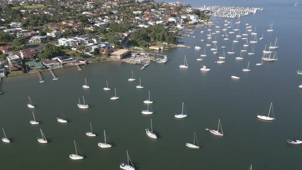 Aerial flyover Kogarah Bay Marina and Waterfront property and houses with decks featuring yacht, spe