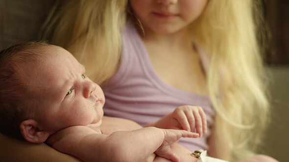 New Big Sister Holds Baby Brother alt