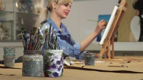 Selective Focus on a Bunch of Paintbrushes Female Artist Working on Her Painting