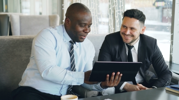 Cheerful African American Businessman in Formal Clothes Using Digital Tablet Discussing Startup