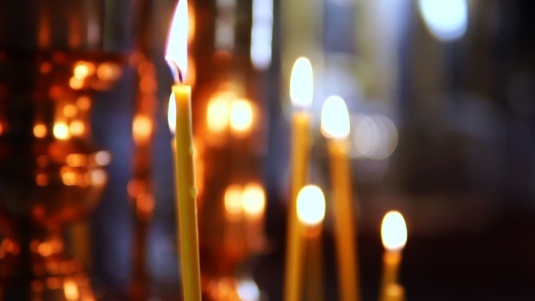 Burning Candle Out of Focus in the Altar in the Christian Church