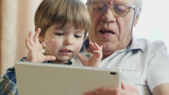 Grandfather Using Digital Tablet With Grandchildren